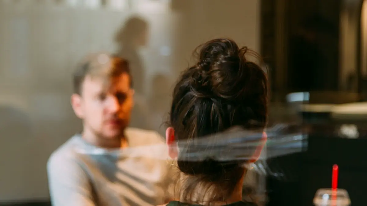 Person sitting in a chair in front of a man.
