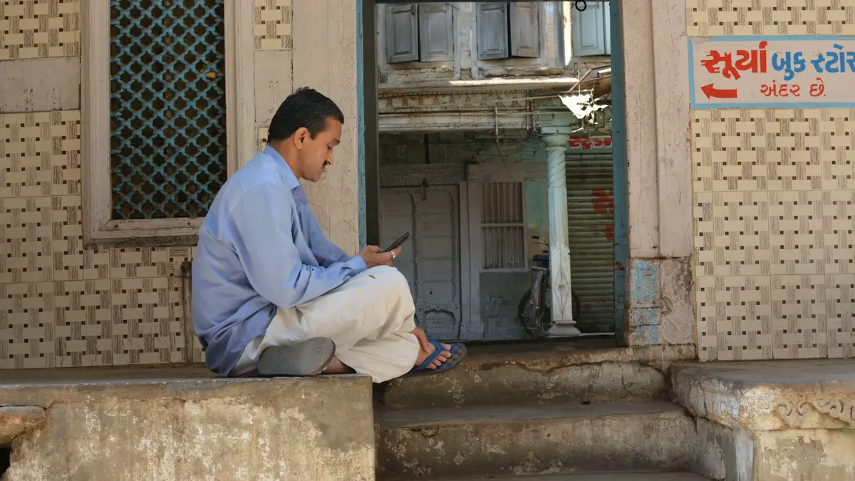 Man sitting on steps looking at phone.