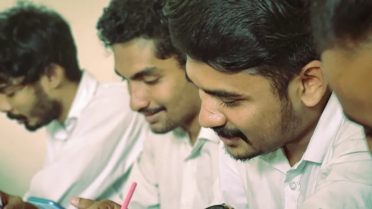 A group of men sitting at a table writing on paper.
