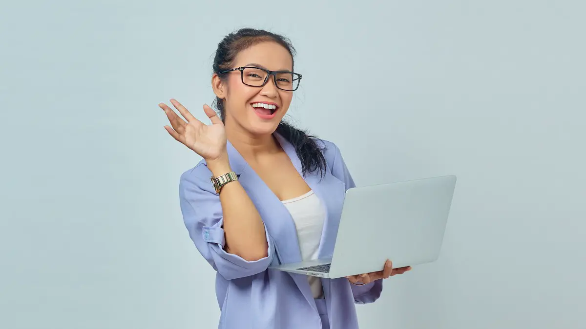 A woman in glasses is holding a laptop.