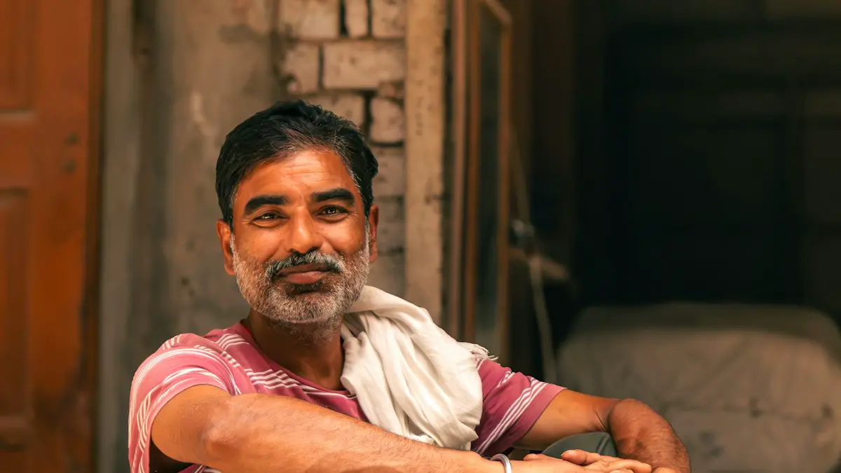 Smiling bearded man sits on a wooden cart with boxes.