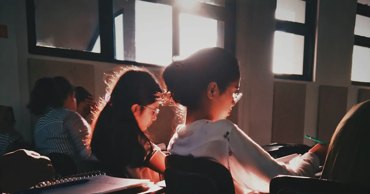 Students writing answers in a classroom.