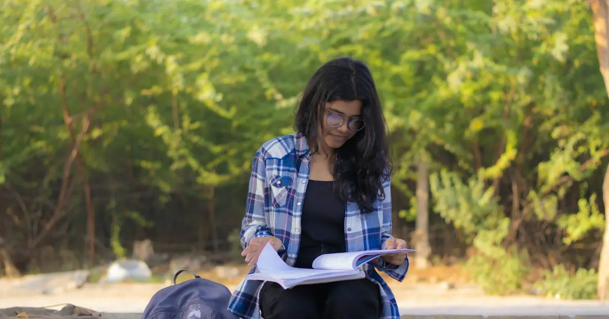 A student studying her notes outdoors.