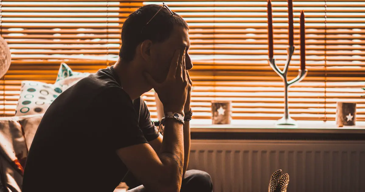 A man sitting with his head in his hands.