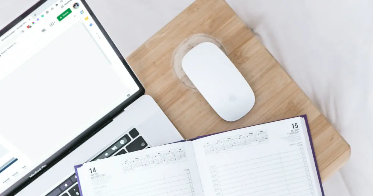 A spreadsheet on a laptop beside a diary.