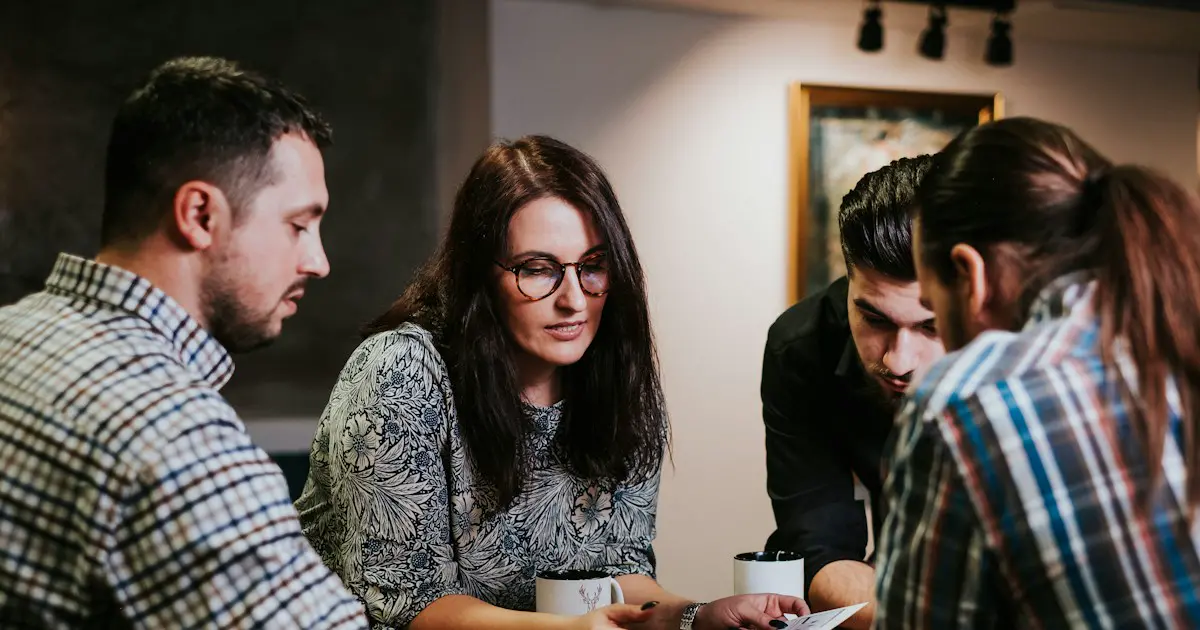 A team gathered around a laptop, working on code.