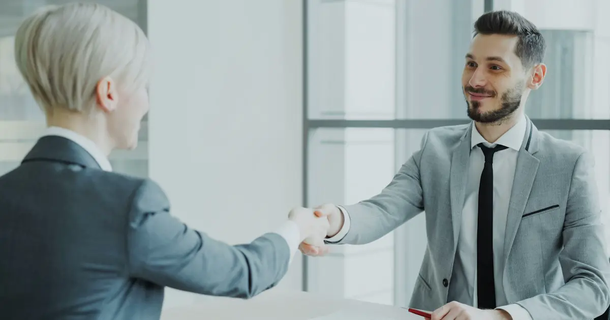 An interviewer shaking hands with a candidate.