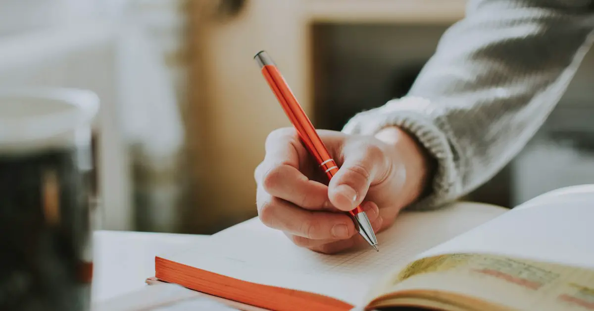 Writing notes by hand at a desk.
