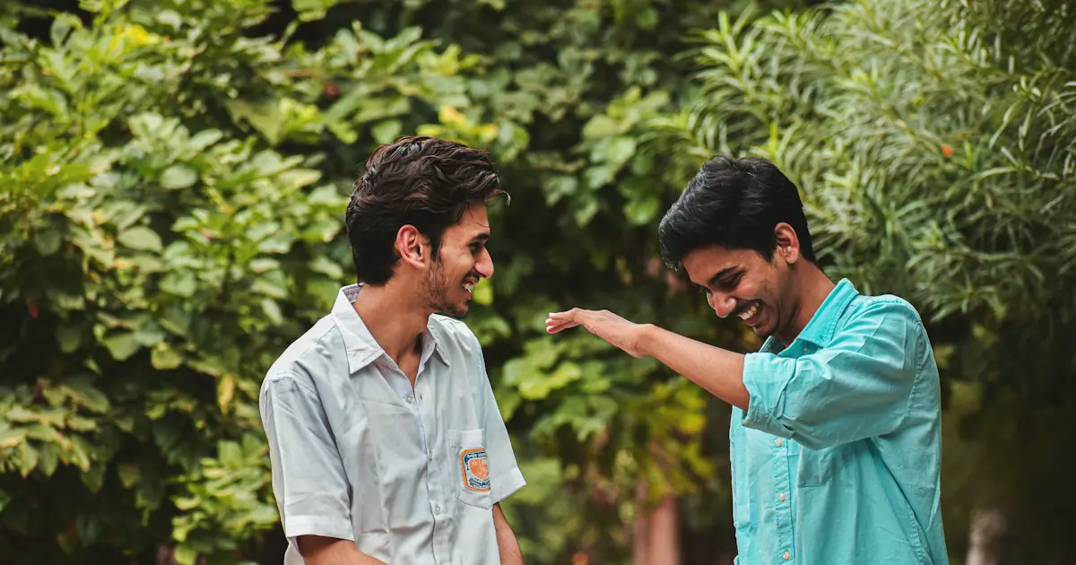 Two young men in an easy conversation outdoors.