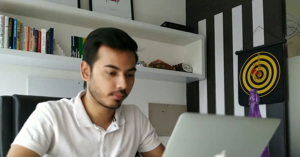 A young man practising at his laptop at home.