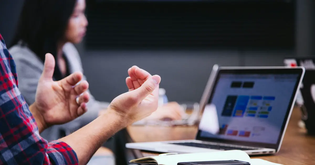 Explaining a point with open hands across a table.