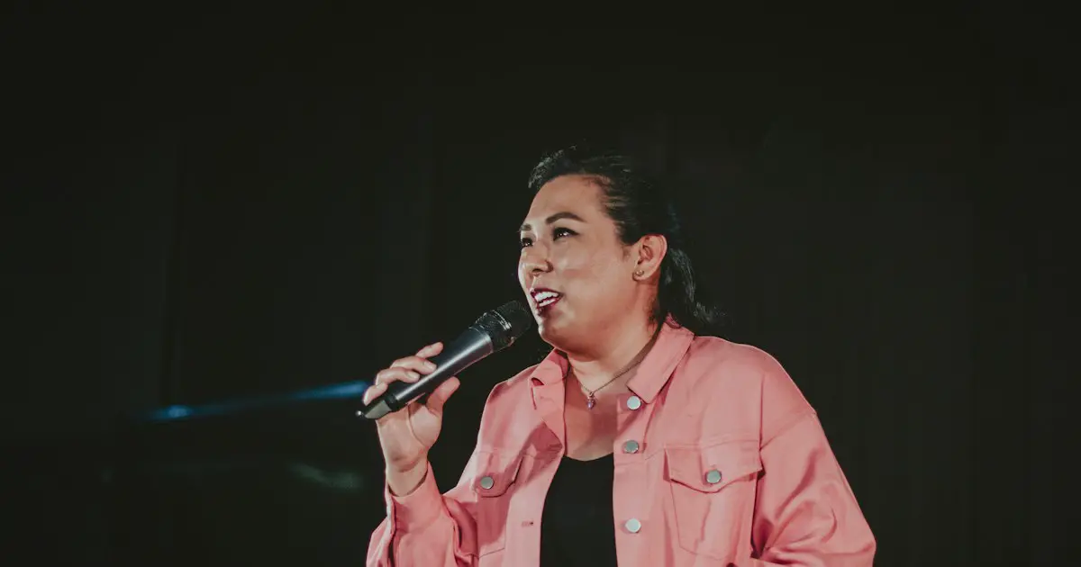Someone speaking into a microphone on stage.