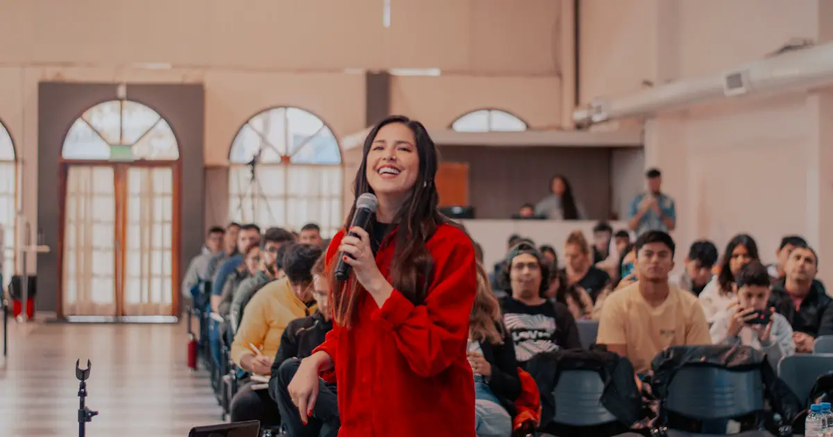 A student speaking with a microphone in front of an audience.