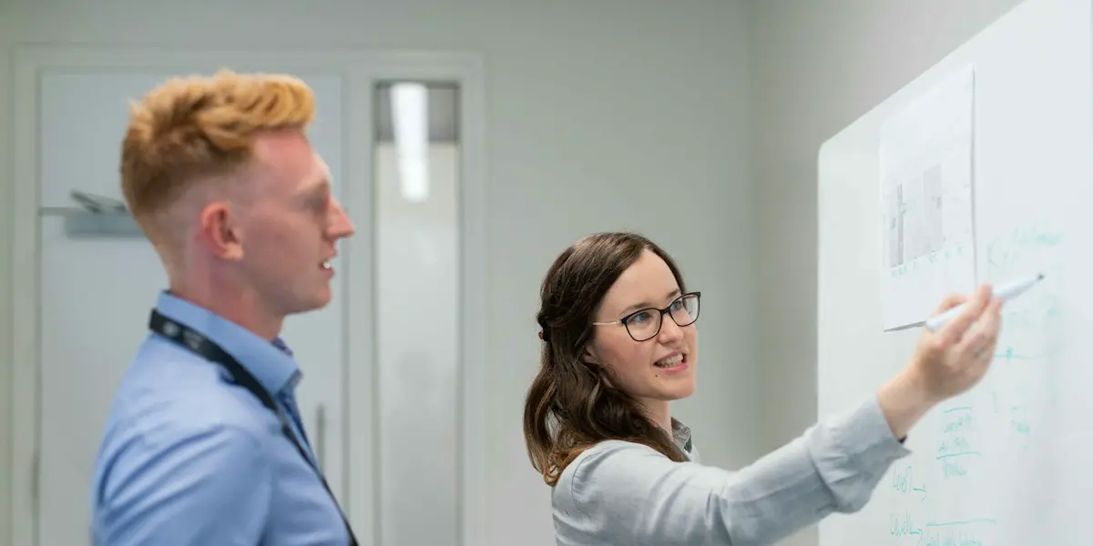 A business analyst mapping a process on a whiteboard.